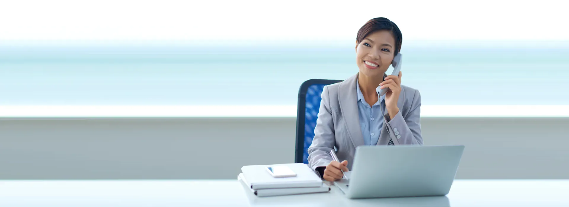 Asian woman receptionist talking on the phone